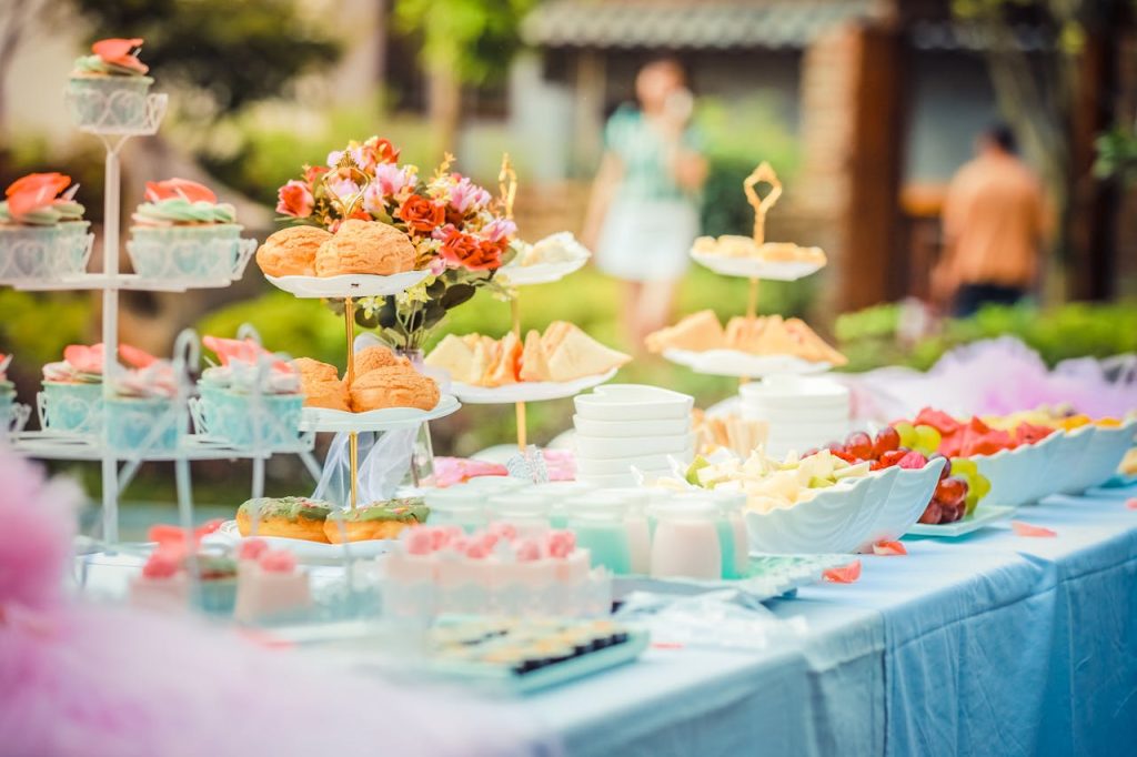 various-desserts-on-a-table-covered-with-baby-blue-cover-587741 A vibrant outdoor buffet table showcasing an array of colorful pastries and fruits, perfect for parties.